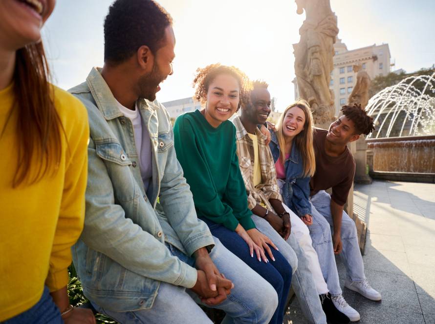 Side view of multiethnic group of Erasmus friends ganging out outdoors having fun.