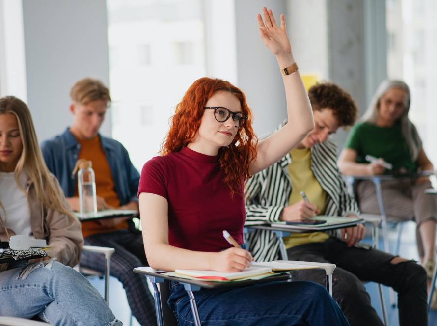 Portrait of group of university students sitting in classroom indoors, studying