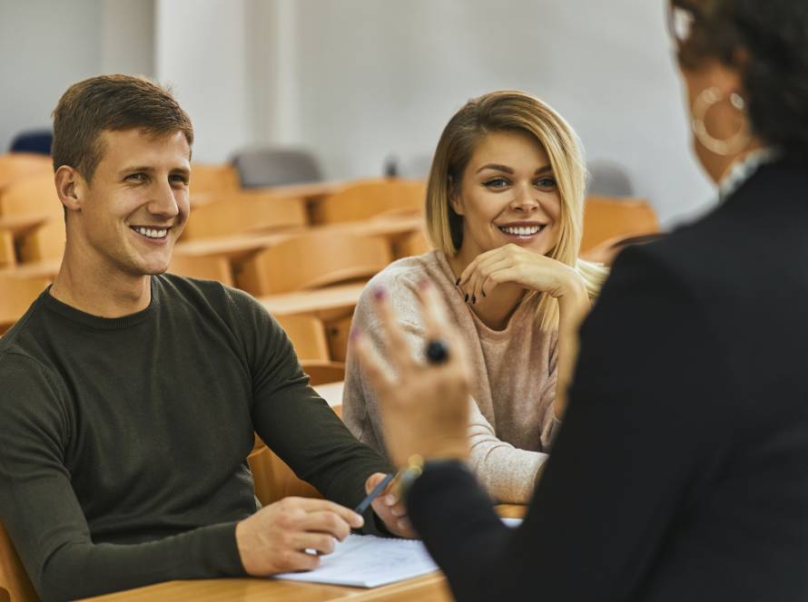 Smiling students and lecturer in auditorium at university